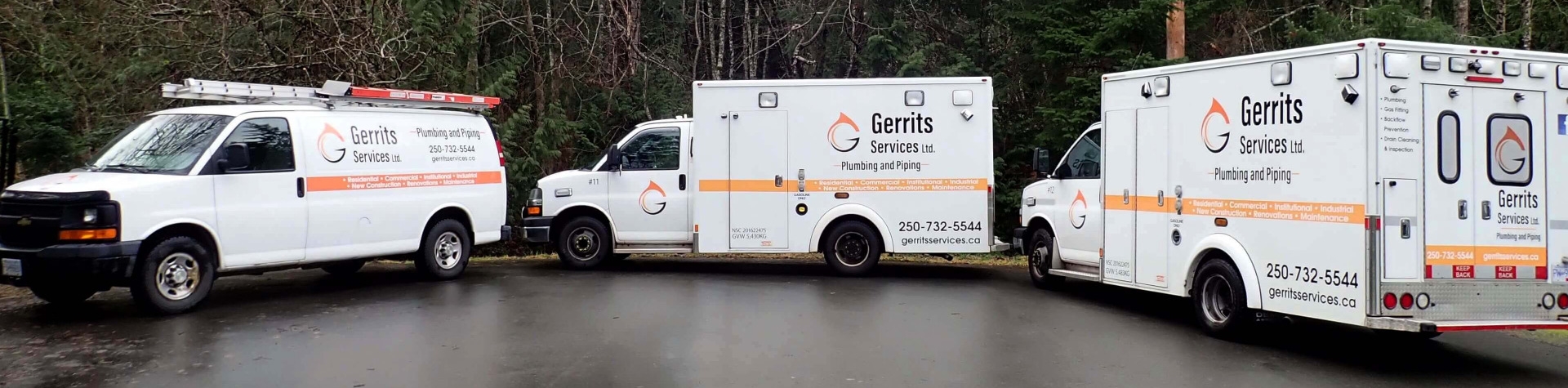 Gerrits Services vehicles parked in front of trees on a rainy day